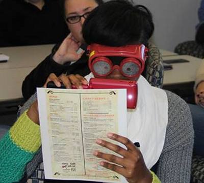 See different participant using vision simulator glasses and a magnifying aid.