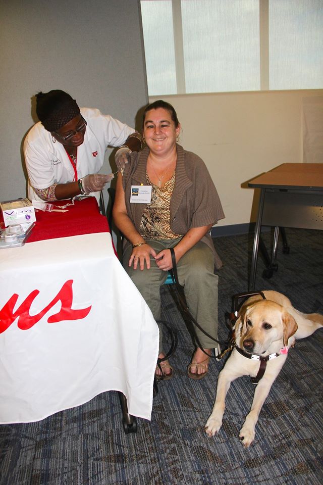 Visually impaired woman gets a flu shot from a CVS pharmacy technician