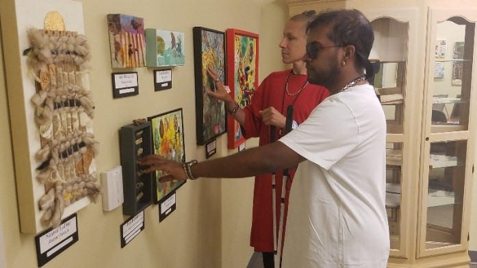 Blind men examining artwork.