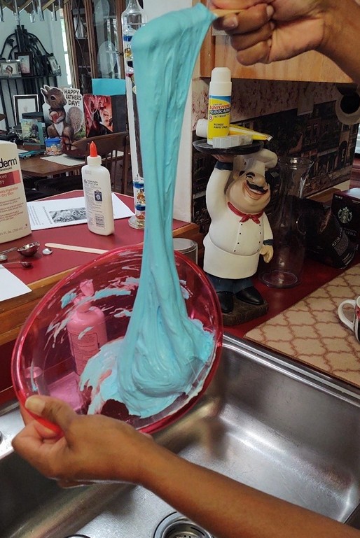 Slime pouring off a stick into a bowl beneath it.